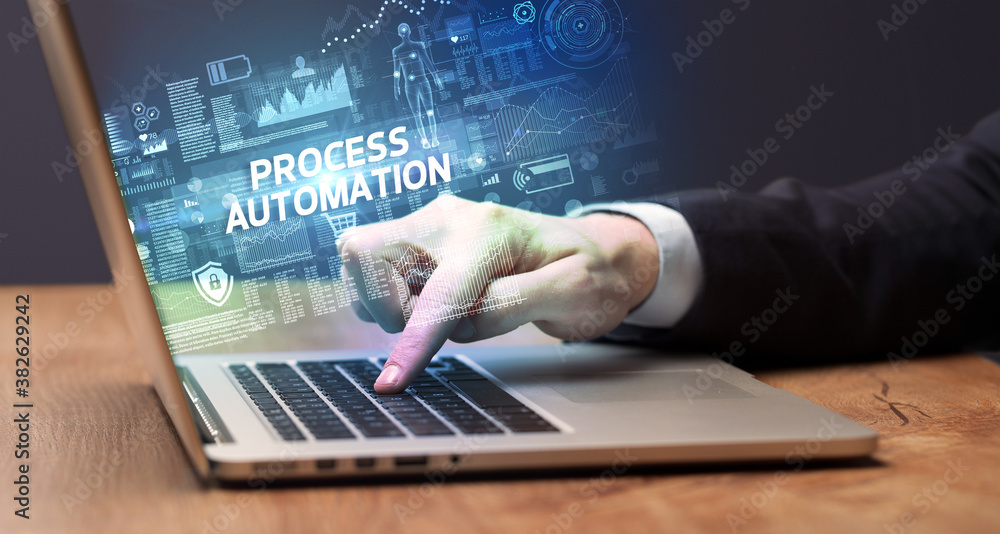 Businessman working on laptop with PROCESS AUTOMATION inscription, cyber technology concept Businessman working on laptop with PROCESS AUTOMATION inscription, cyber technology concept