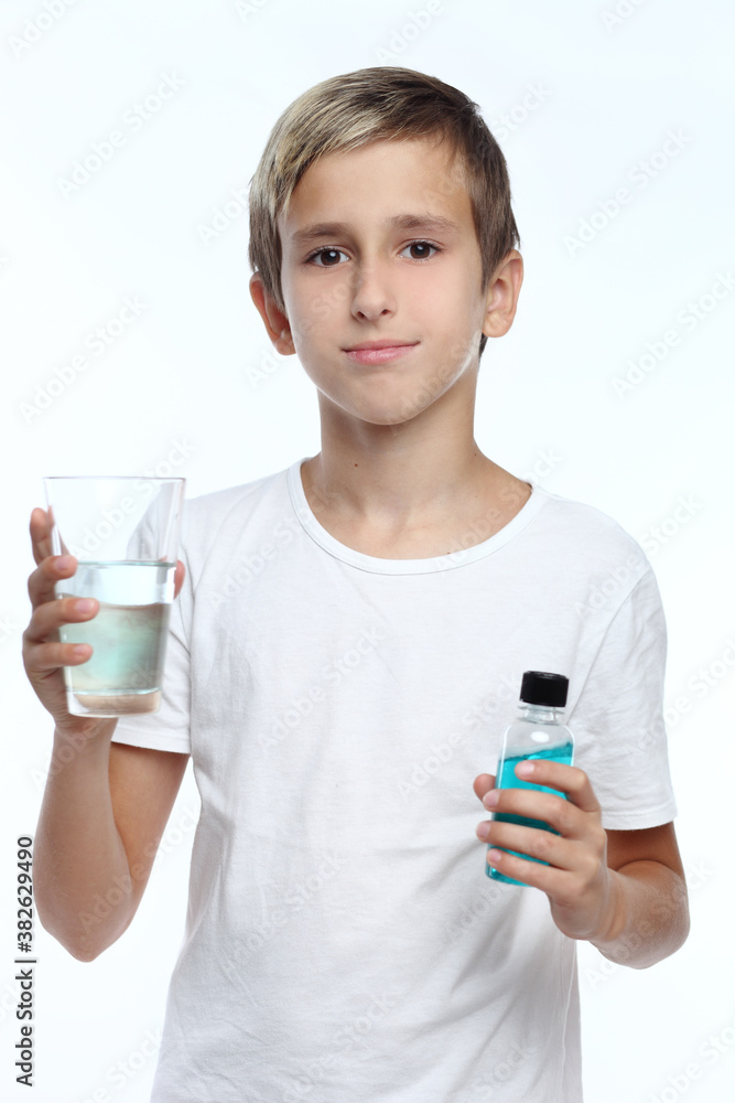 Cute boy with white background, wearing braces on his teeth. Spray a disinfectant mouthwash in the throat. Cute boy with white background, wearing braces on his teeth. Spray a disinfectant mouthwash in the throat.