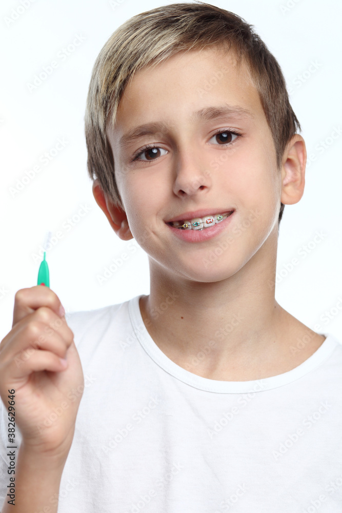 Boy with braces smiling while brushing your teeth Boy with braces smiling while brushing your teeth