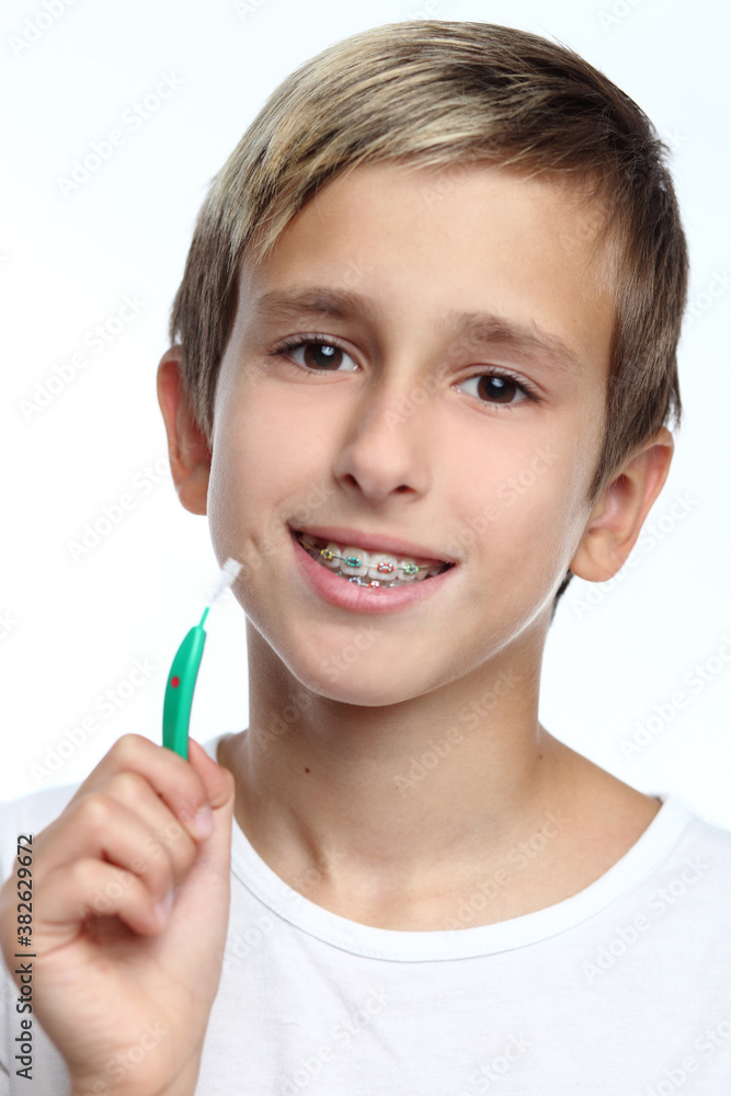 Boy with braces smiling while brushing your teeth Boy with braces smiling while brushing your teeth