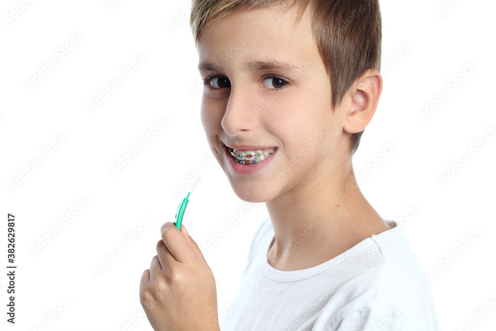 Boy with braces smiling while brushing your teeth Boy with braces smiling while brushing your teeth