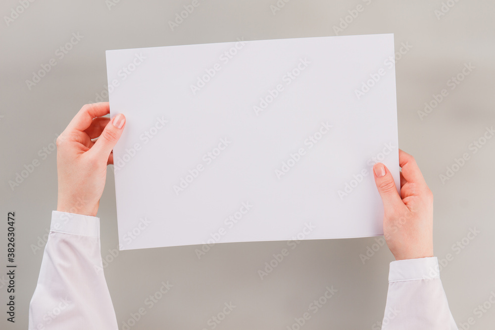 Hands of business woman holding empty paper. Place for business advertisement. Hands of business woman holding empty paper. Place for business advertisement.