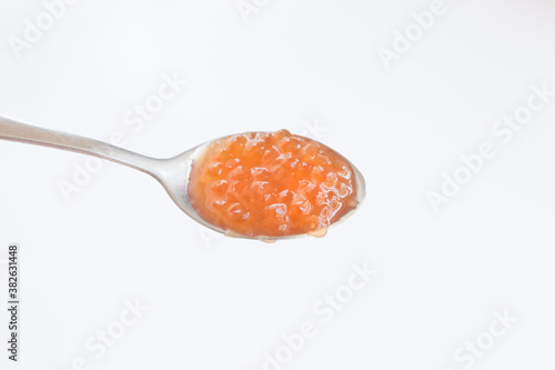  Red caviar on a metal spoon close-up. Concept for Christmas and New Year festive dishes. Healthy natural red salmon caviar