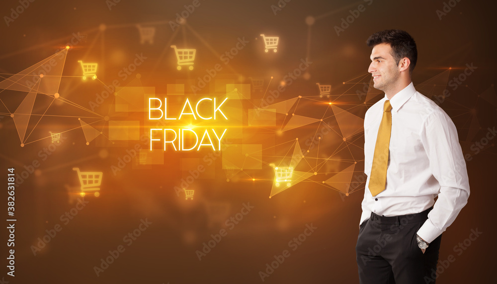 Businessman with shopping cart icons and BLACK FRIDAY inscription, online shopping concept Businessman with shopping cart icons and BLACK FRIDAY inscription, online shopping concept