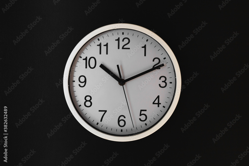 White clock on the black wall White clock on the black wall