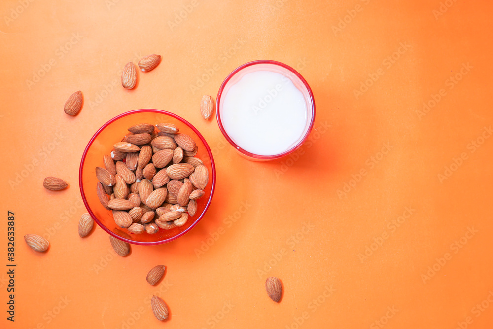 almond nut and milk on orange background top down almond nut and milk on orange background top down