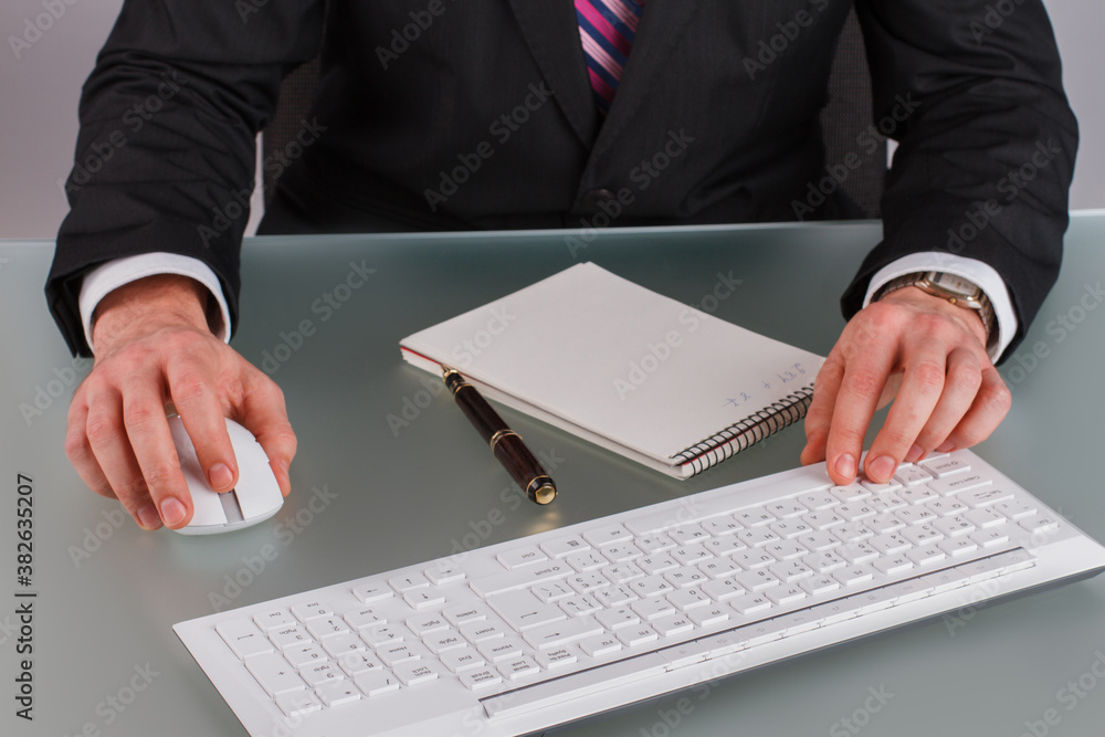 Close up of businessman hands working on computer at office. Male corporate working at table in office. Close up of businessman hands working on computer at office. Male corporate working at table in office.