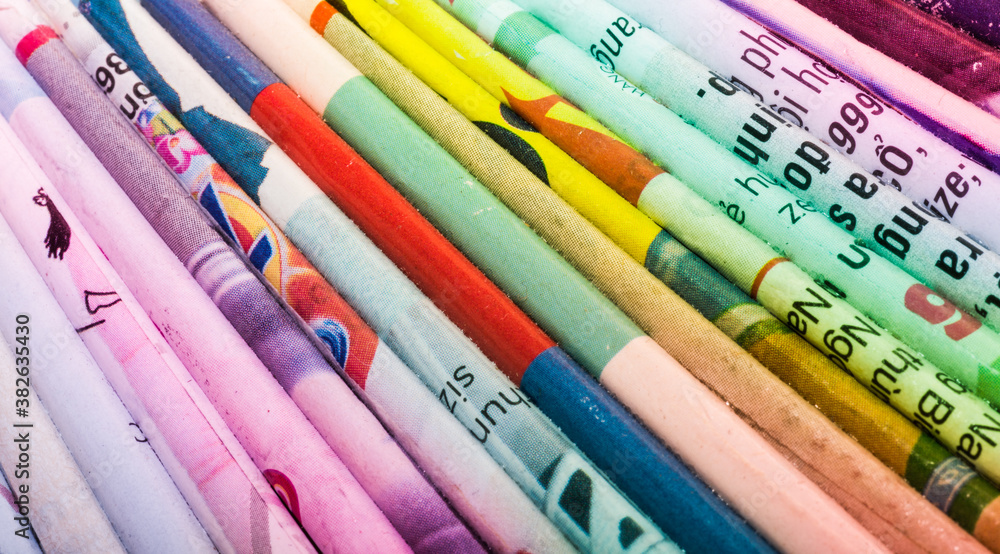 Colourful book covers lined up on a shelf in a study