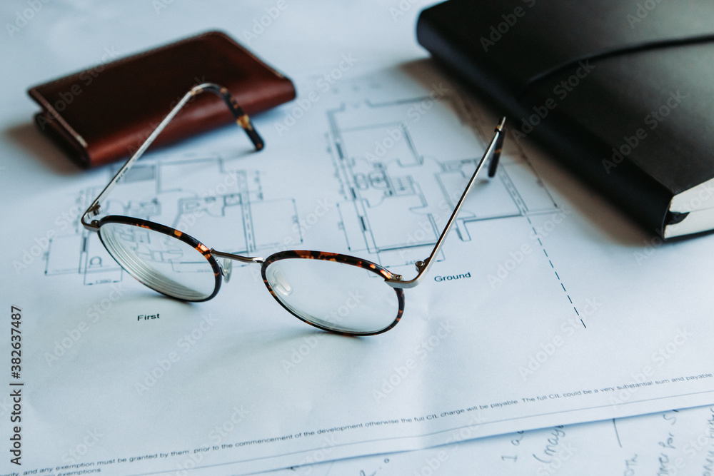 Glasses resting on floorplans in an office. Glasses resting on floorplans in an office.