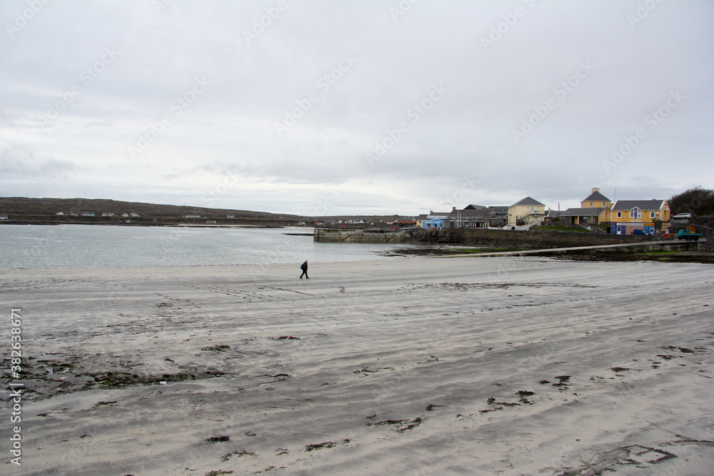 It coasts next to a small village with low tide and cloudy skies in Ireland It coasts next to a small village with low tide and cloudy skies in Ireland