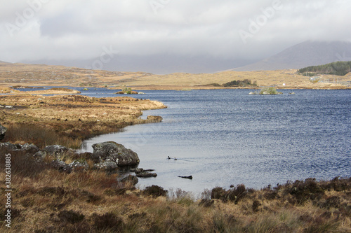 Lake in the middle of a dry landscape and a very cloudy sky in Ireland