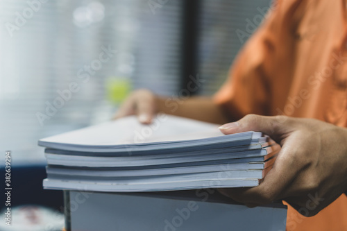 фотографія Office workers employee holding stacks of lot documents report papers waiting be managed on desk in busy office
