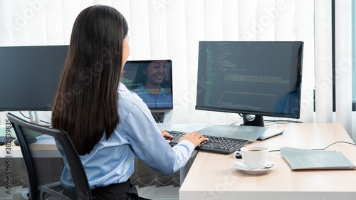 Asian woman Programming working with computer and typing data code to developing program at table In Office  technology concept