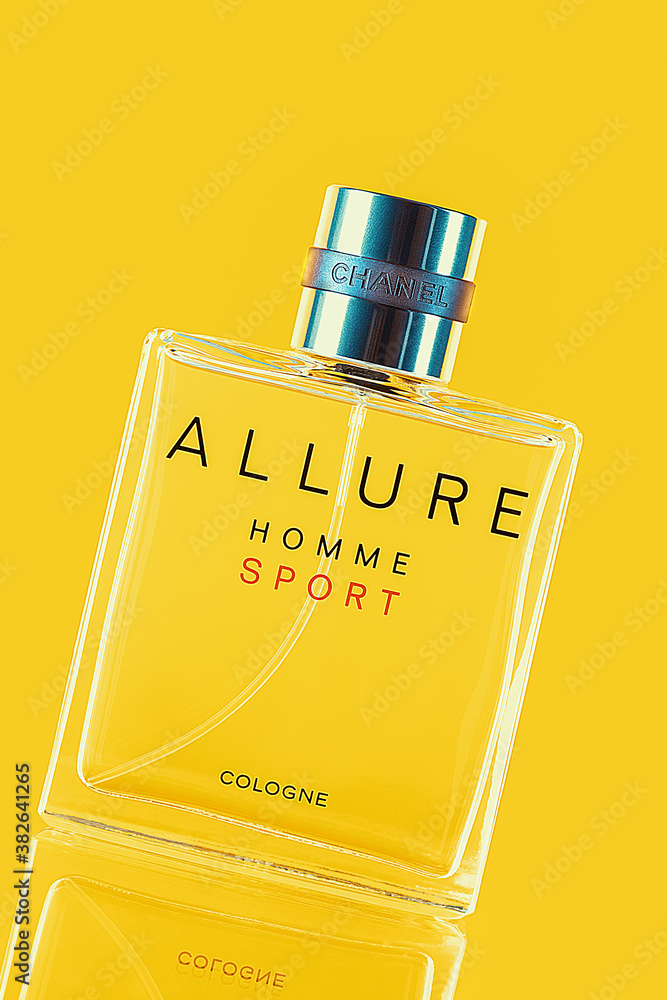 A bottle of Chanel perfume on a yellow background, with a reflection of the lower part. Allure men's perfume series. 2020-07-05 Samara. Photo | Adobe Stock