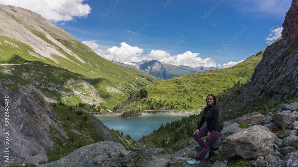 Girl on one of the Europe top 10 best hiking trails with crystal clear blue sky and lake