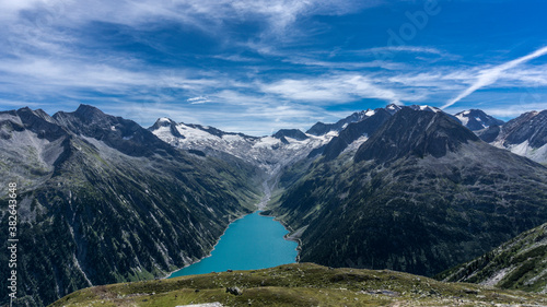 Stunning view to crystal clear blue lake in Austria alpine mountains with blue sky and glaciar