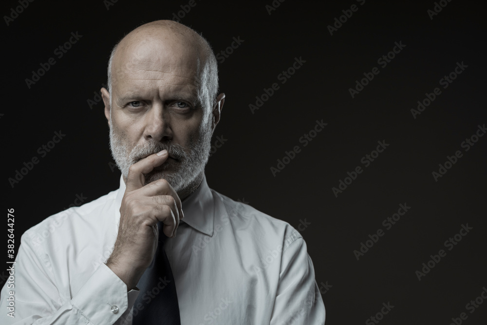 Confident businessman thinking with hand on chin Confident businessman thinking with hand on chin