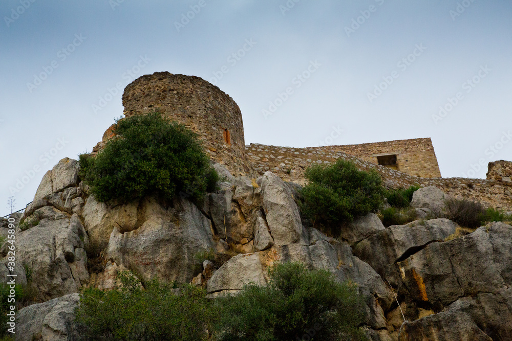 Vista de torre defensiva de castillo beige y rocas grises erosionadas