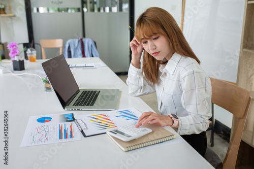 Young Business women are stressing about numbers with calculator and laptop at office ,a stress-to-work concept. © David