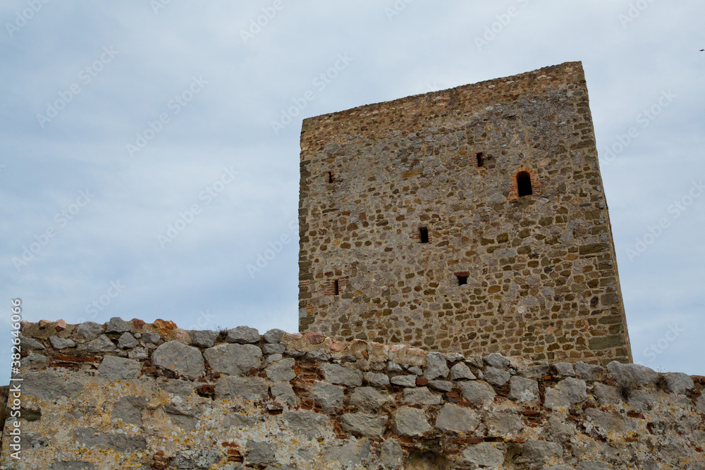 Muralla interna y torre de piedra beige con cielo nublado