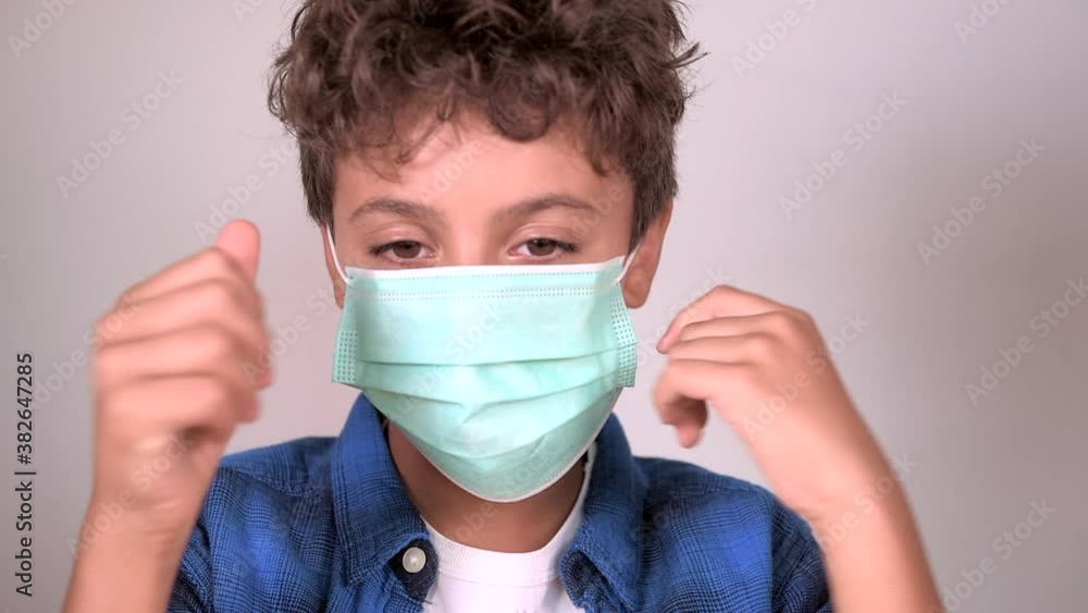 smiling child boy putting on surgical mask for coronavirus prevention smiling child boy putting on surgical mask for coronavirus prevention