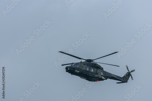 flying green military helicopter at a air show
