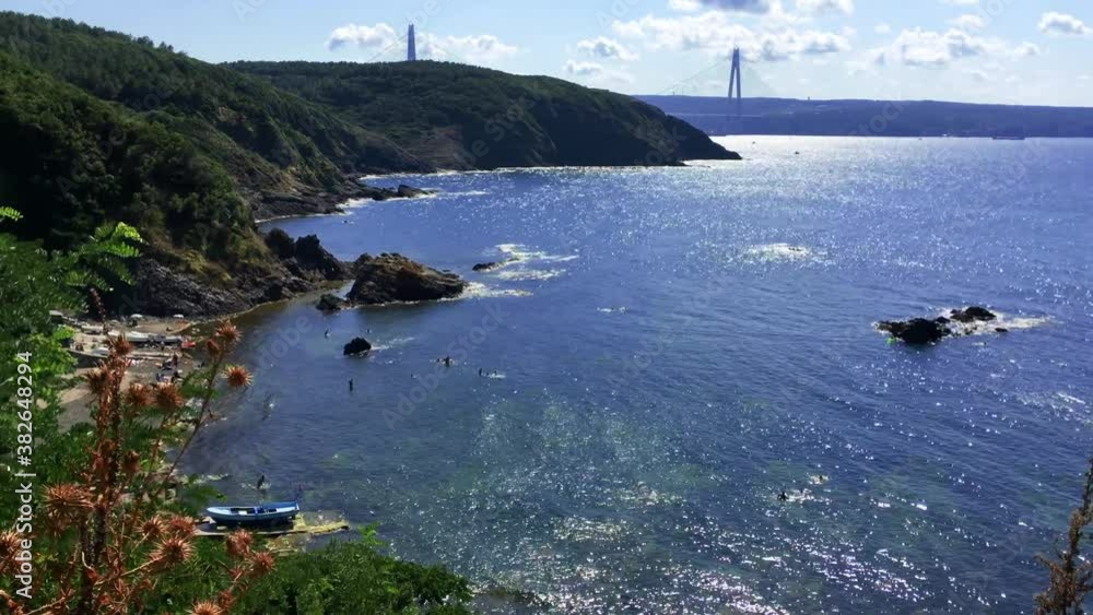 Yavuz Sultan Selim Bridge Timelapse. People are swimming in the bay and ships are passing through the Istanbul strait. Bosphorus traffic with blue sky and cloud. Yavuz Sultan Selim Bridge Timelapse. People are swimming in the bay and ships are passing through the Istanbul strait. Bosphorus traffic with blue sky and cloud.
