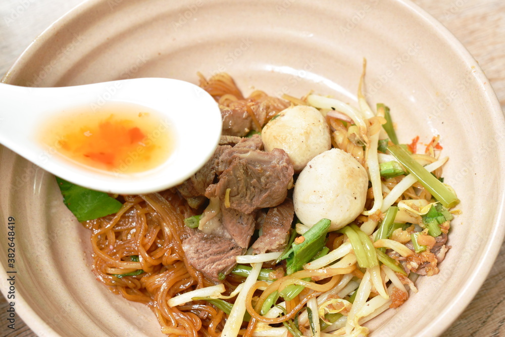 rice noodles topping braised pork and ball on bowl with bone in brown herb soup cup rice noodles topping braised pork and ball on bowl with bone in brown herb soup cup