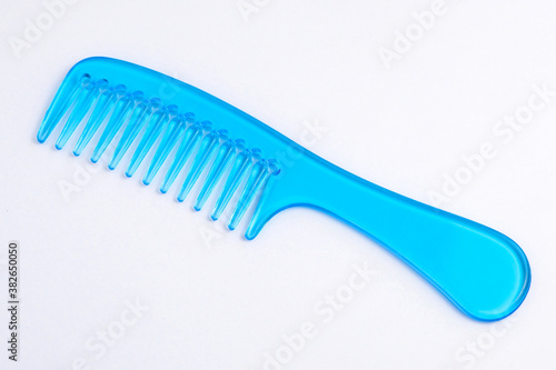 Blue plastic comb on a white background.