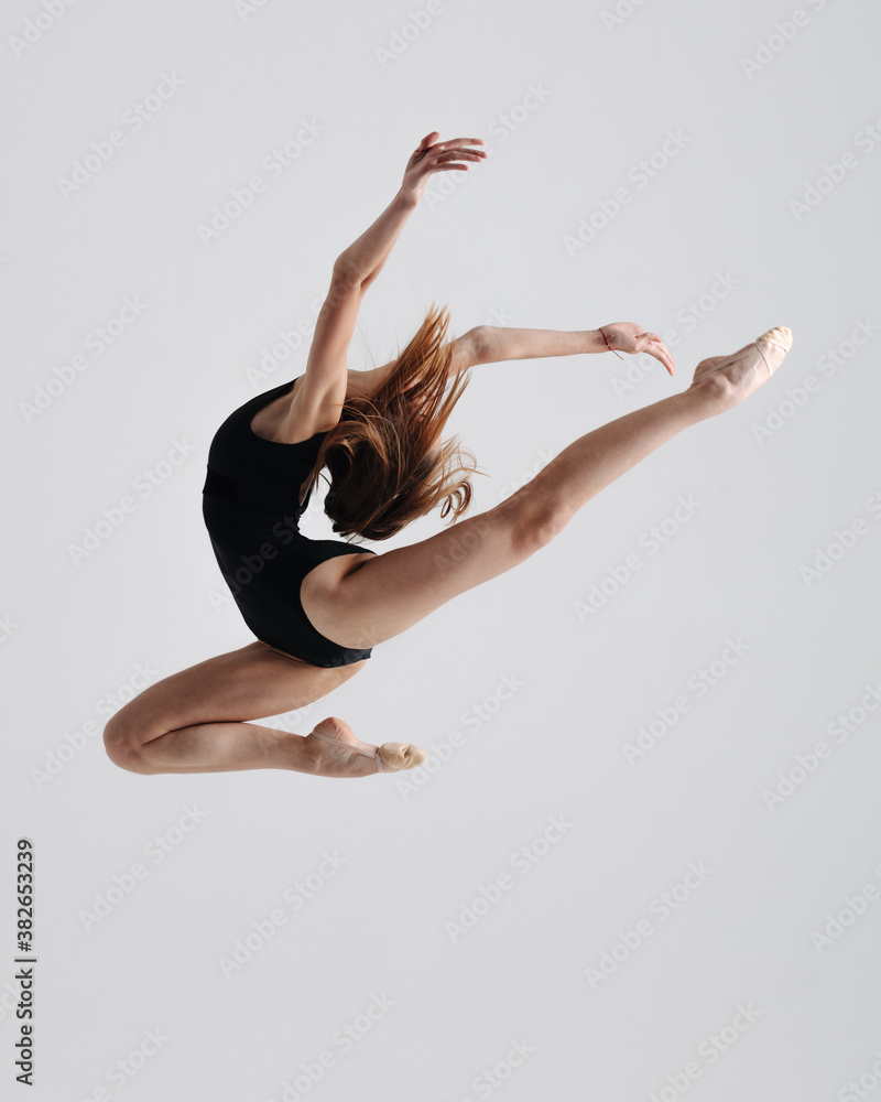 Fototapeta premium Young gymnast girl stretching and training