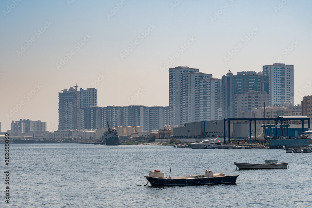 Empty fishing boats on the sea, waiting for its net catch during daytime in the Middle East with city building in the background