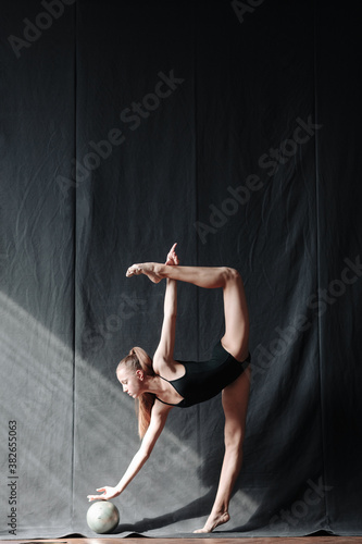 Fototapeta Naklejka Na Ścianę i Meble -  Young gymnast girl stretching and training