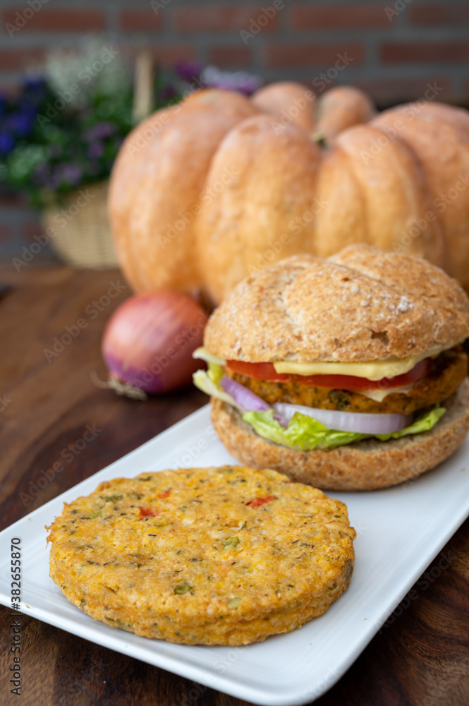 Making fresh and healthy vegetarian hamburgers with grilled pumpkin burgers, organic buns and vegetables Making fresh and healthy vegetarian hamburgers with grilled pumpkin burgers, organic buns and vegetables