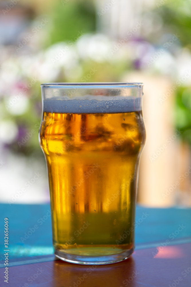 French cold beer in misted glass served on outdoor terrace in small Alpine village in France French cold beer in misted glass served on outdoor terrace in small Alpine village in France