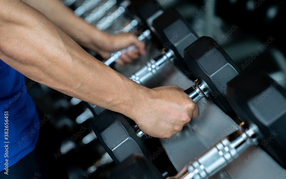 Hand holding dumbbell in the gym, Exercise and health care. Hand holding dumbbell in the gym, Exercise and health care.