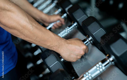 Hand holding dumbbell in the gym, Exercise and health care.