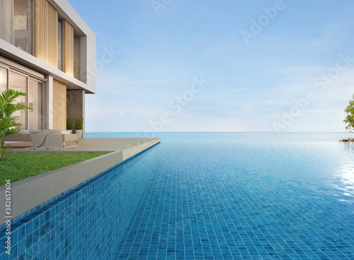 Lounge chair on terrace near swimming pool and garden in modern beach house or luxury villa. Building exterior 3d rendering with sea view. © MIRROR IMAGE STUDIO