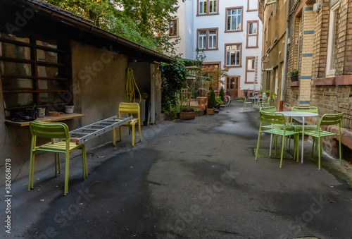 Hinterhof mit bunten Stühlen und alten Bäumen in einer deutschen Studentenstadt, Heidelberg © Stephan