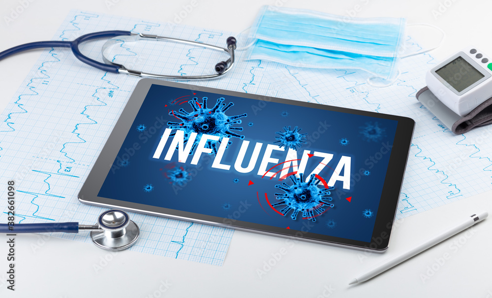 Tablet pc and doctor tools on white surface with INFLUENZA inscription, pandemic concept Tablet pc and doctor tools on white surface with INFLUENZA inscription, pandemic concept