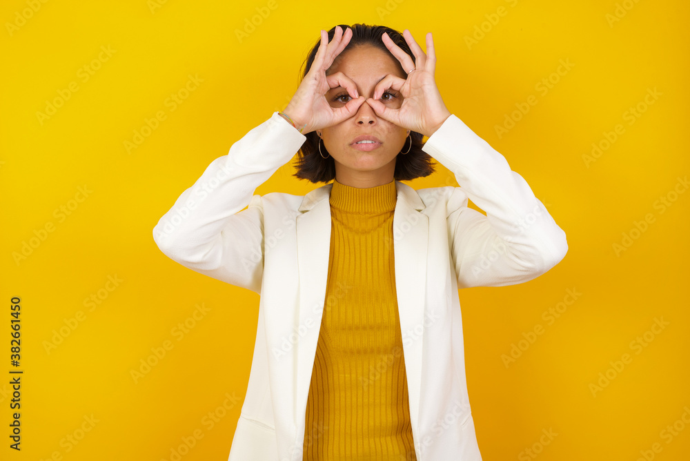 Playful excited teenage female with dark long hair showing Ok gestures with both hands, pretending to wear spectacles, astonished to see something amazing. Emotions, body language and gestures� Playful excited teenage female with dark long hair showing Ok gestures with both hands, pretending to wear spectacles, astonished to see something amazing. Emotions, body language and gestures�