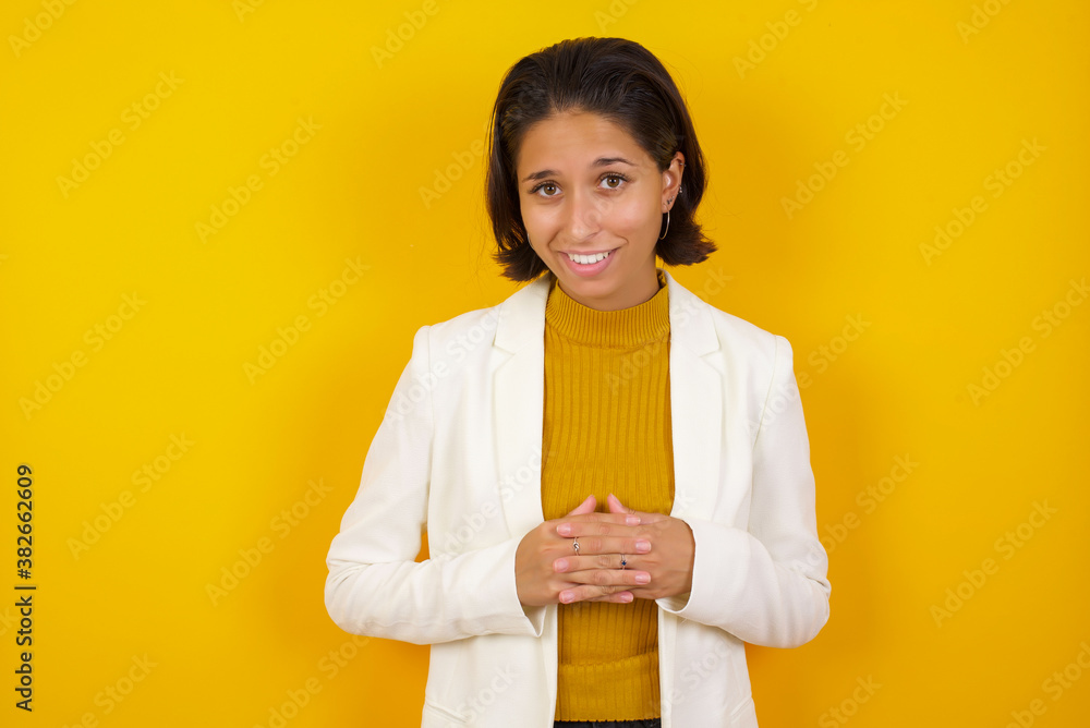 Girl turn attention at camera, distracted from smartphone smiling friendly and happily holding mobile phone as, taking selfie in mirror, showing friends new outfit, standing in dressing room of mall. Girl turn attention at camera, distracted from smartphone smiling friendly and happily holding mobile phone as, taking selfie in mirror, showing friends new outfit, standing in dressing room of mall.