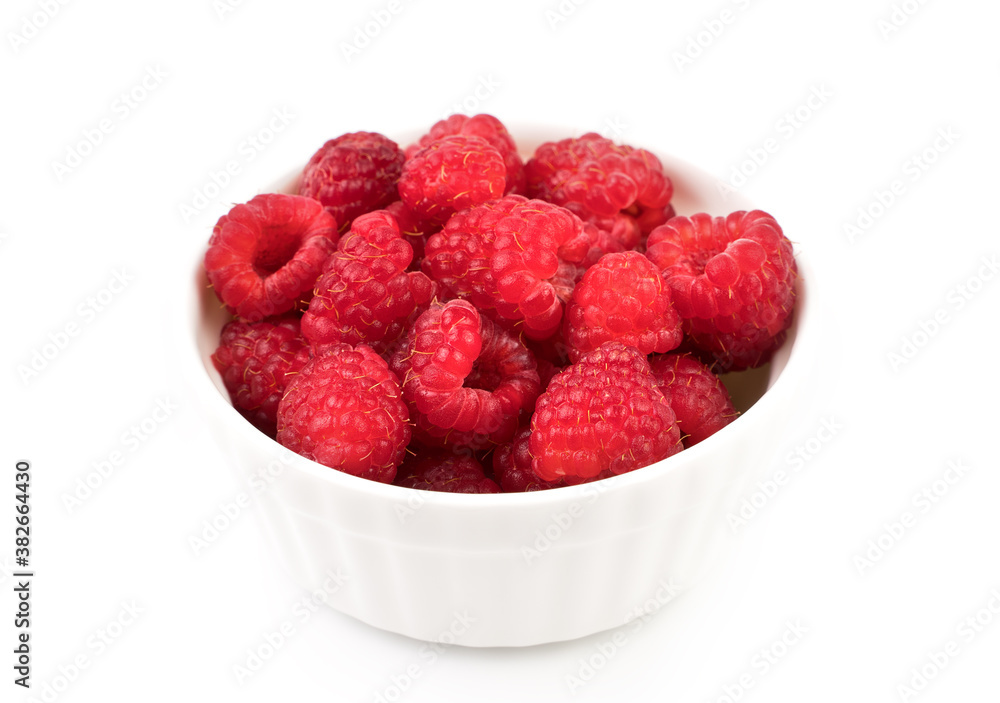 Raspberries are collected in a white Cup on a white background. Berry background. The concept of natural products. Raspberries are collected in a white Cup on a white background. Berry background. The concept of natural products.