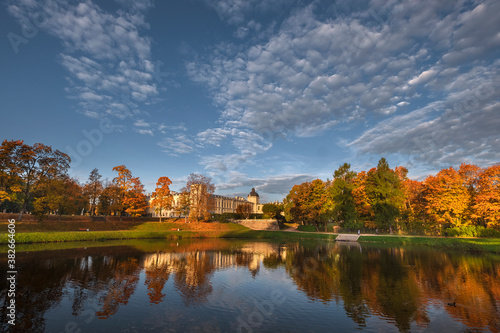A palace and park in the city of Gatchina in the Leningrad Region is reflected in the water during a golden autumn.