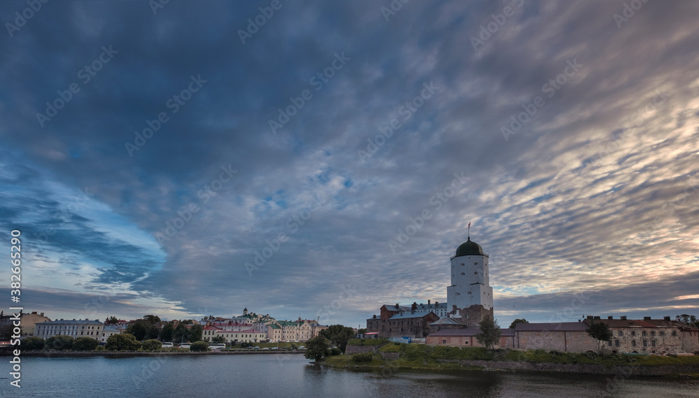 An ancient castle in the city of Vyborg in Russia with St. Olaf Tower on the shore of the Gulf of Finland in early autumn evening