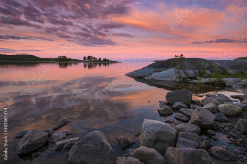 Beautiful sunset on Lake Ladoga in Karelia, Russia in the Ladoga Skerries national park in summer. Natural landscape with water rocks, stone islands and forest near shore