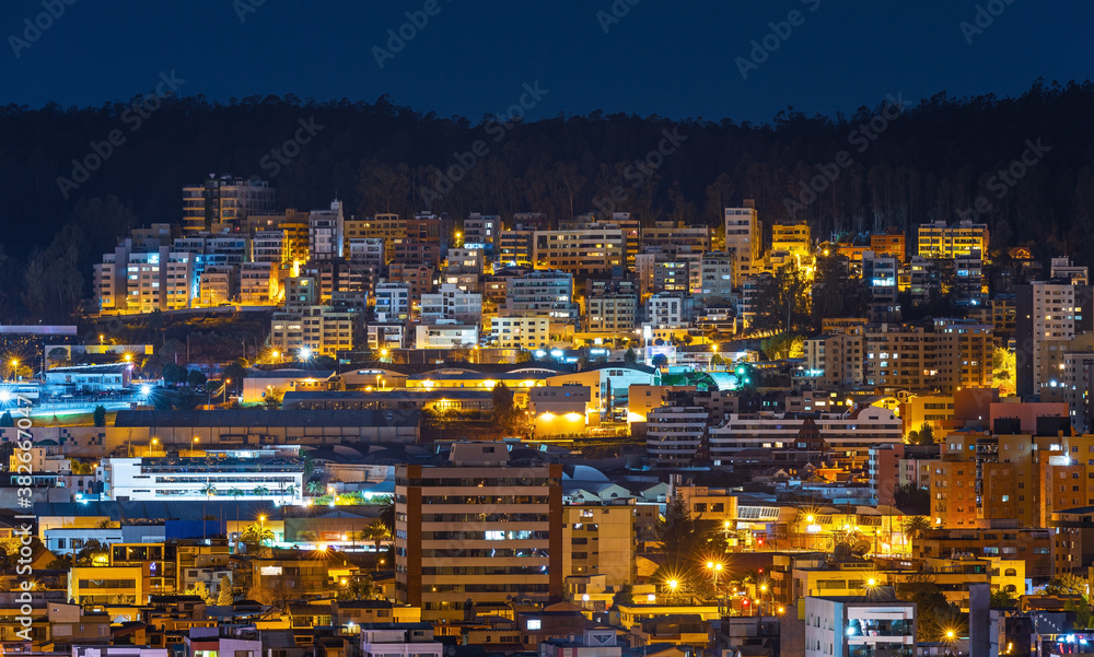 Aerial cityscape of modern apartment buildings at night, Quito, Ecuador.