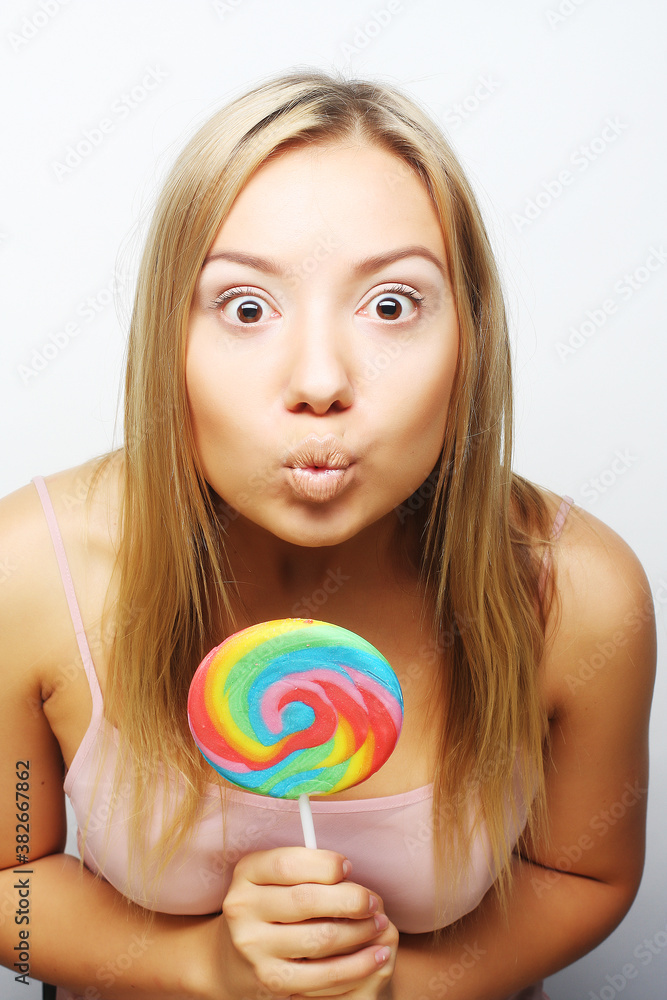 beautiful young woman with big colorful lollipop