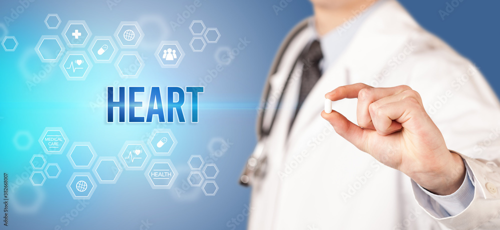 Close-up of a doctor giving you a pill with HEART inscription, medical concept Close-up of a doctor giving you a pill with HEART inscription, medical concept
