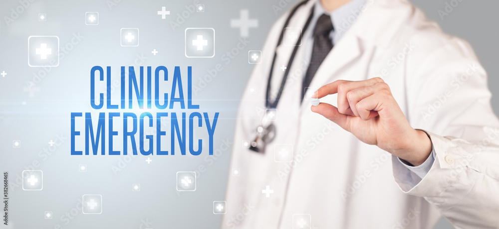Close-up of a doctor giving a pill with CLINICAL EMERGENCY inscription, medical concept Close-up of a doctor giving a pill with CLINICAL EMERGENCY inscription, medical concept