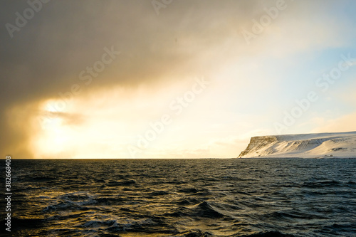 The fjord and the sun  a rare moment of blue sky in the artic ocean 